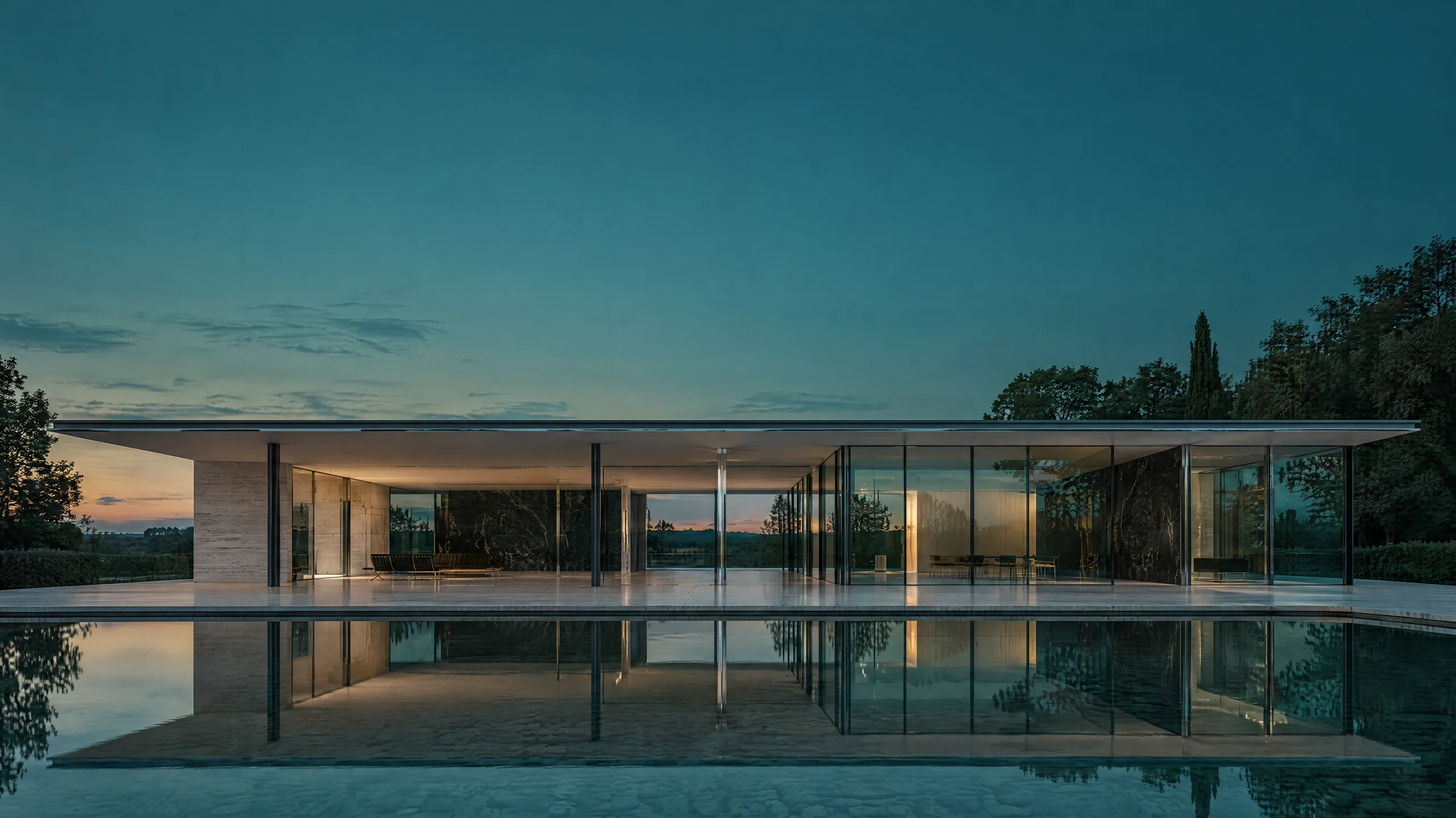 Lange, flache Glashalle mit dünner Dachplatte hinter einem stillen Wasserbecken in der Dämmerung, das Glas spiegelt einen tiefen petrolfarbenen Himmel.